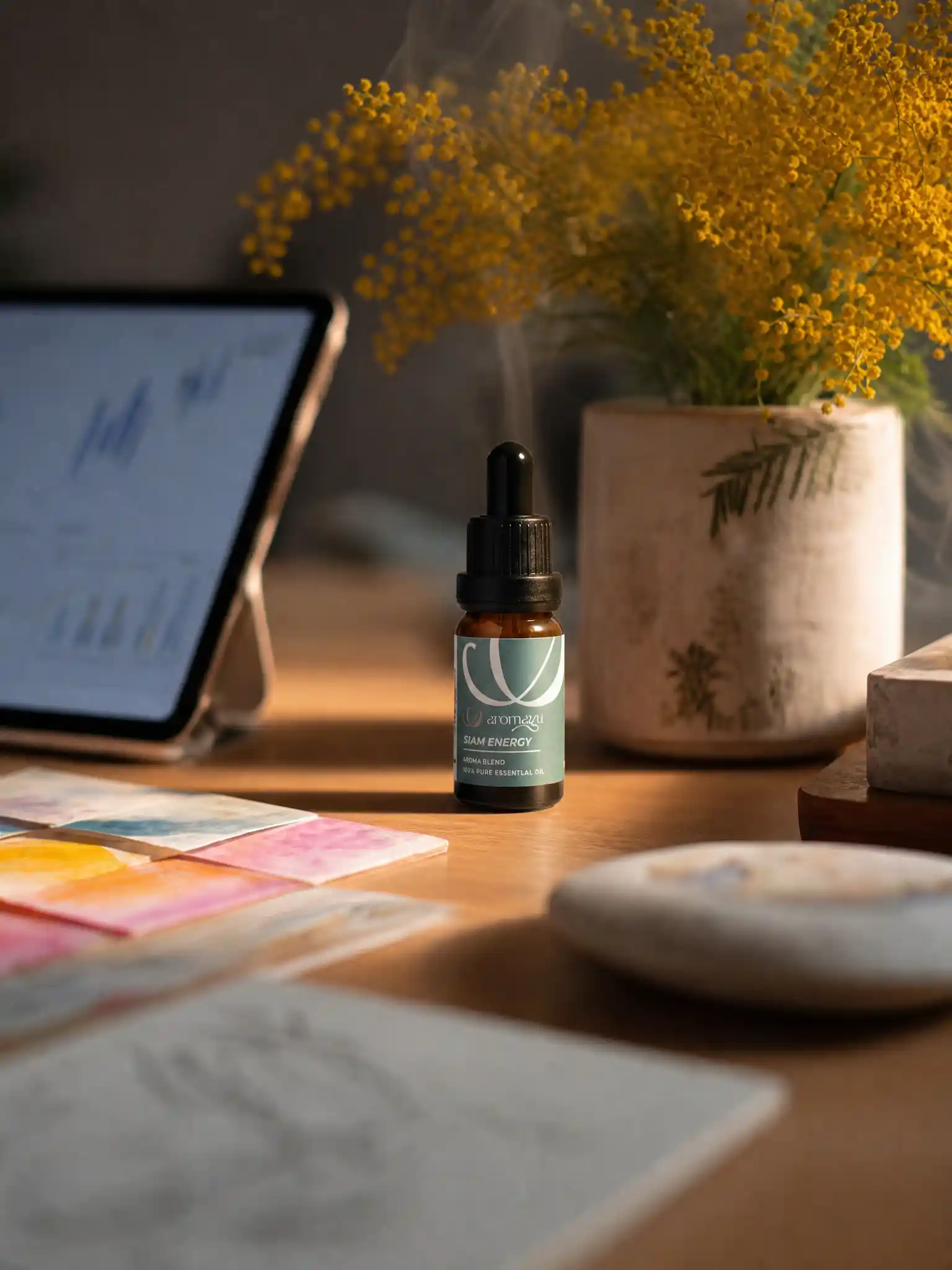 Siam Energy essential oil with makhwaen, placed on a work desk for alertness, from AROMAYU