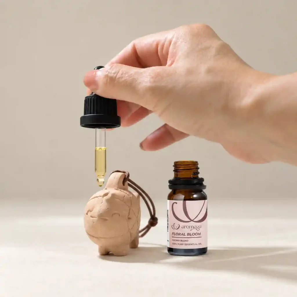 Adding drops of AROMAYU essential oil to a terracotta diffuser.