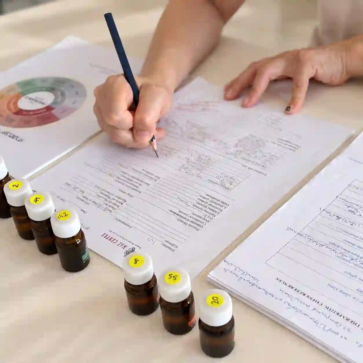 Essential oil formulation notes and sample bottles used to study fragrance blending.